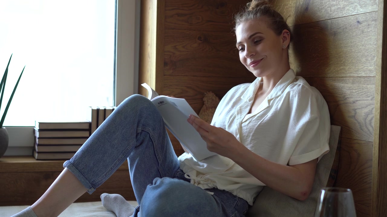 Young Woman Reading a Magazine by a Window