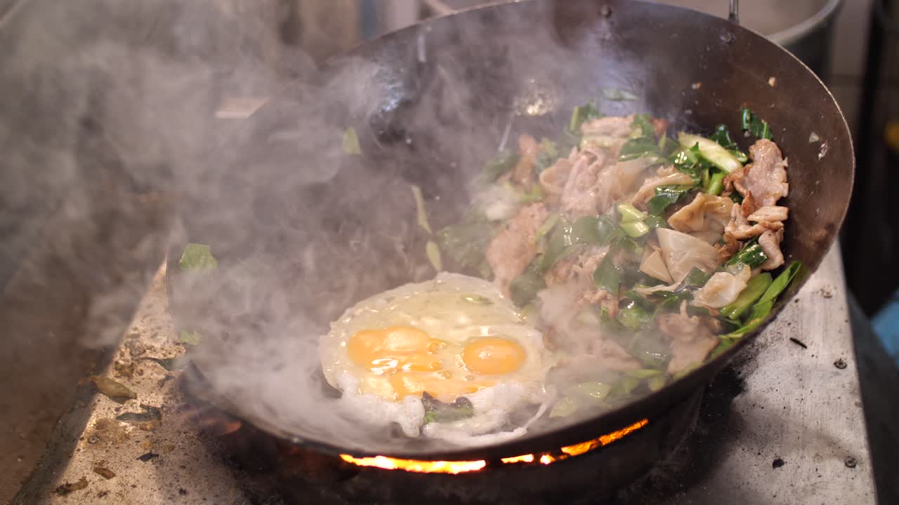 Chef che cucina un delizioso soffritto in un wok