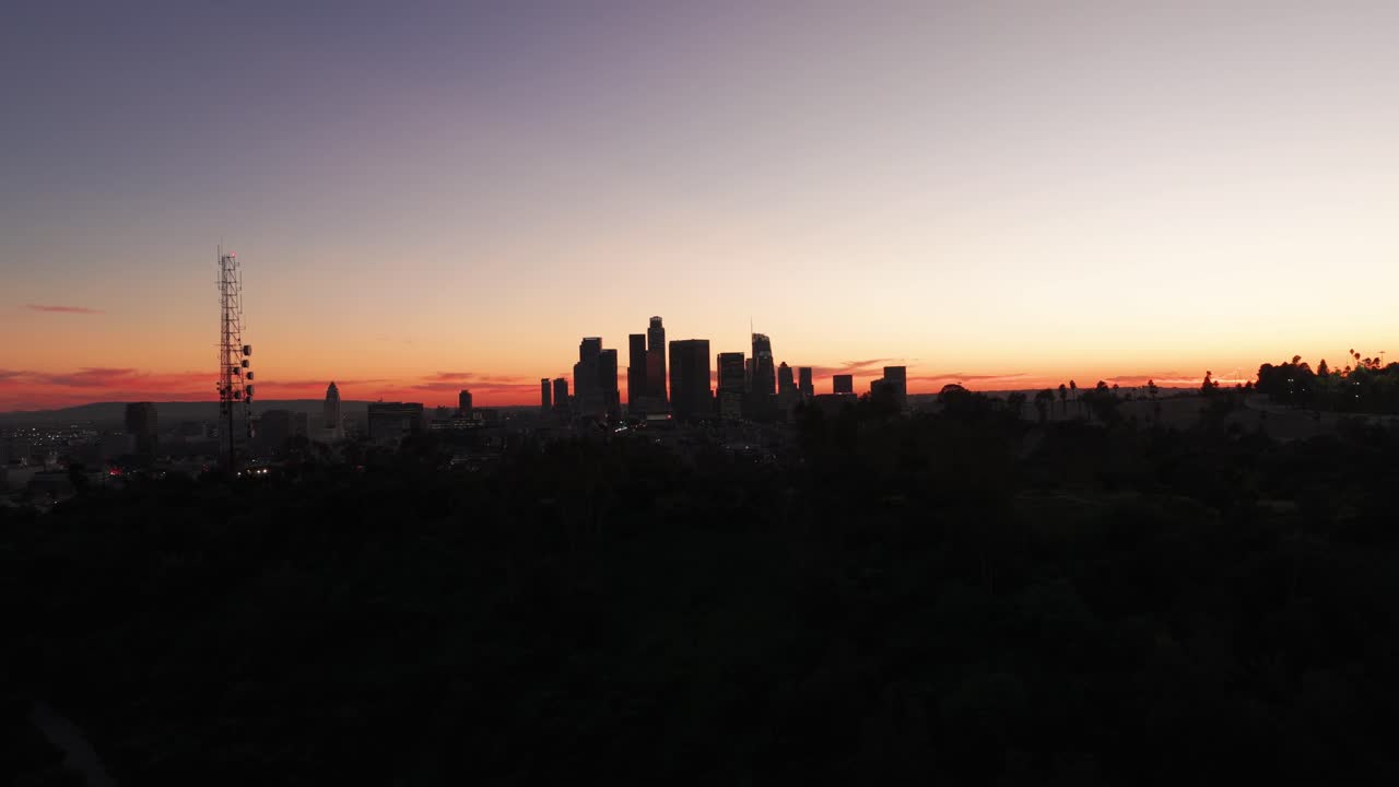 Amplia toma aérea ascendente del centro de Los Ángeles desde Elysian Park al anochecer en el sur de California. 4K.
