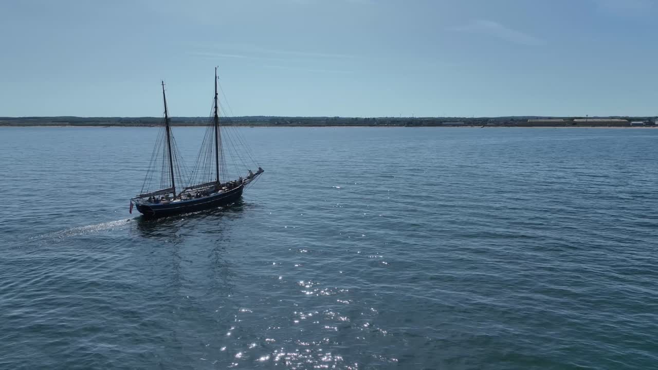 Drone clip showing tall ship with 2 masts sailing through calm sea
