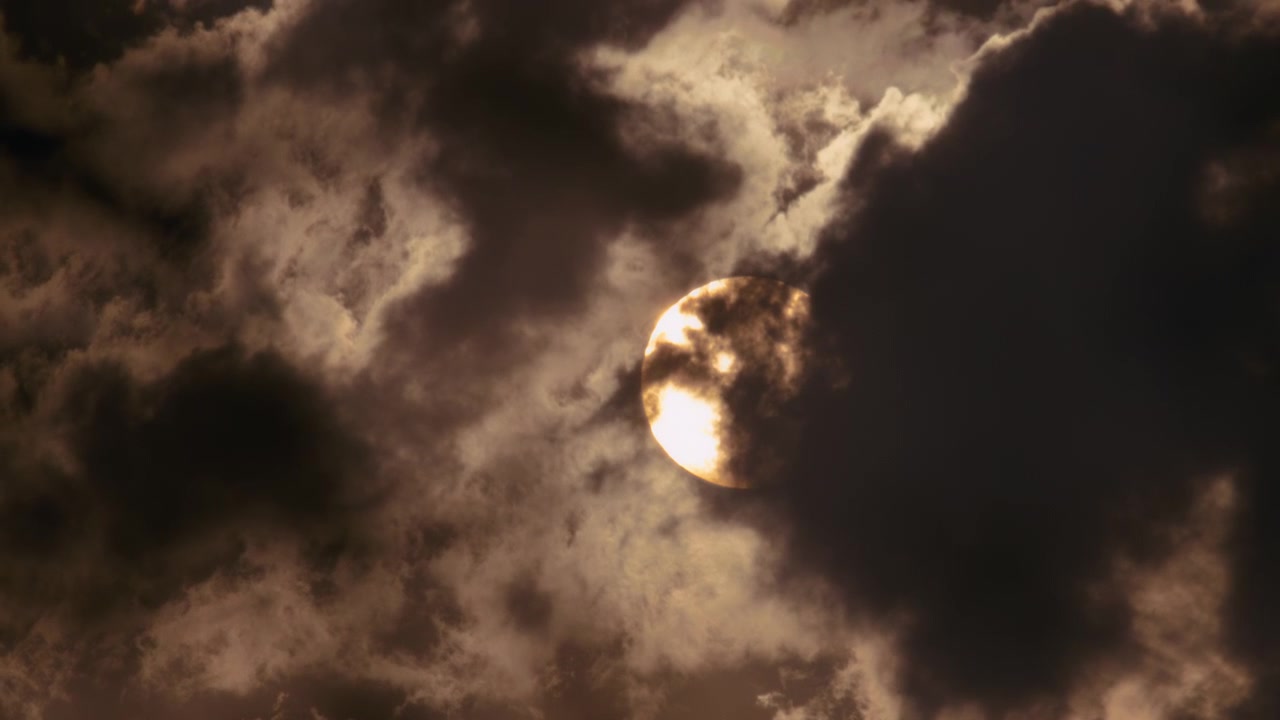 Close up of round sun disk behind the clouds