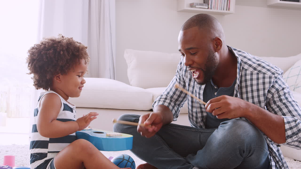 Young black dad and his young daughter playing instruments