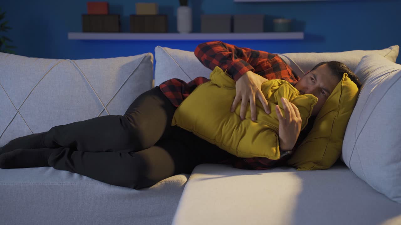 두려움으로 머리에 베개를 누르는 사람.