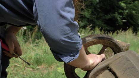 man repairing a wheelbarrow wheel