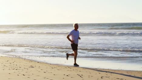 senior man jogging on beach