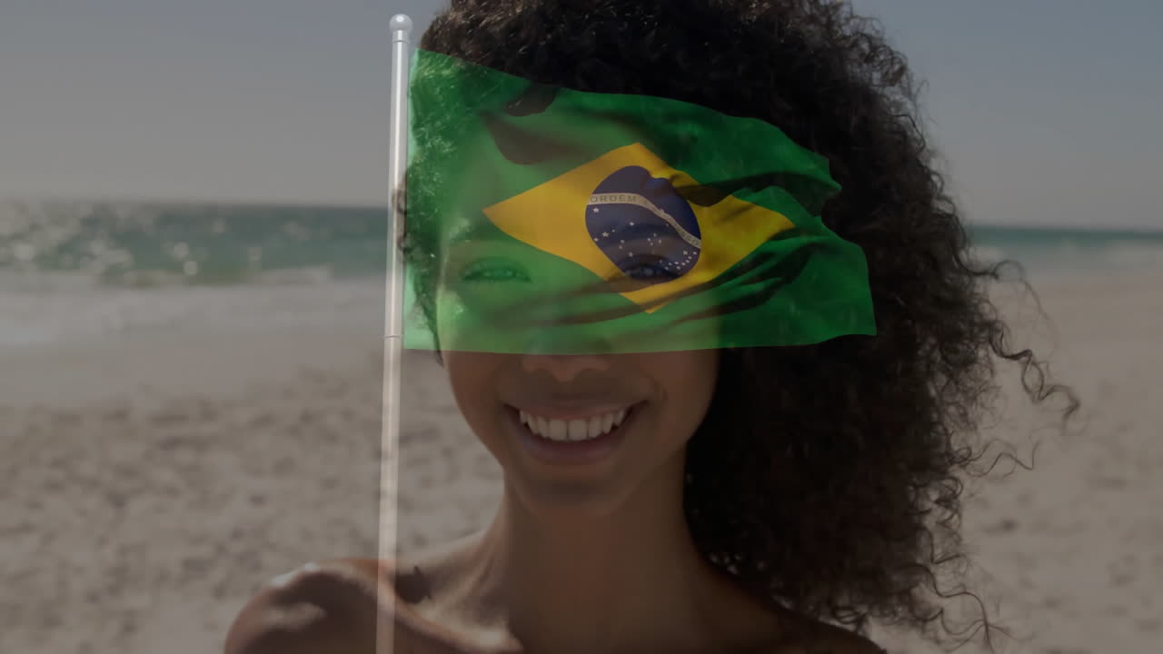 Holding Brazilian flag, person smiling with animation overlay on face at beach