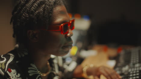 black sound engineer producing music in recording studio