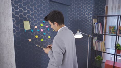 office worker takes notes and sits at his desk.