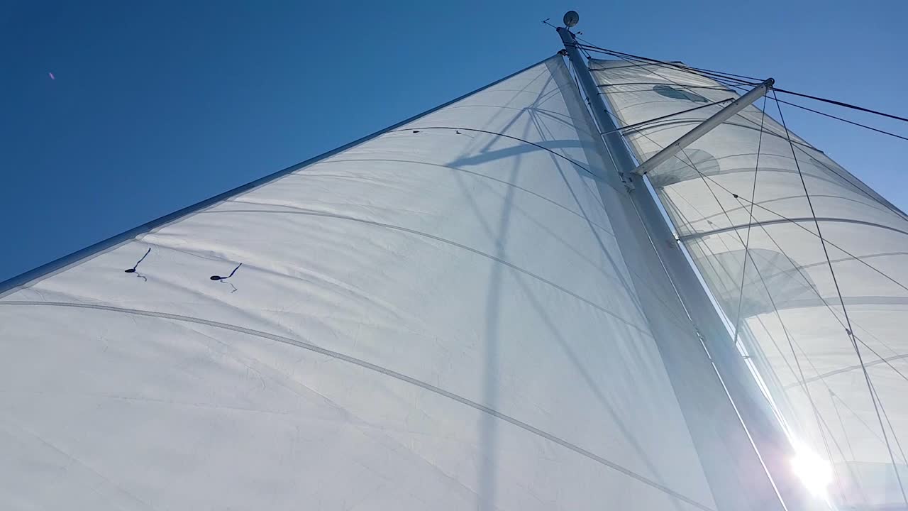 화창한 날씨와 푸른 하늘에서 카타마란 돛대와 하얀 돛의 세로 보기