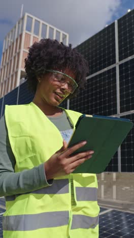 woman inspecting solar panels with a tablet