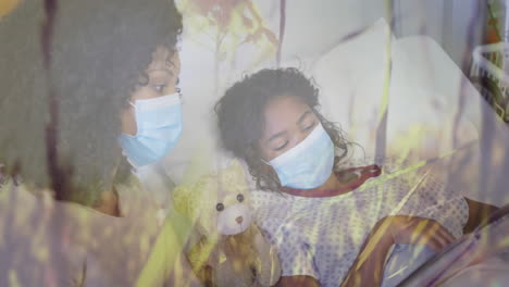 animation of grass over biracial mother with face masks and her daughter lying in hospital