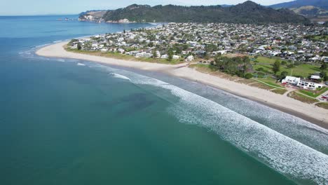 Playa-De-Arena-Y-Ciudad-De-Vacaciones-En-La-Península-De-Coromandel,-Nueva-Zelanda---Toma-Aérea-De-Drones