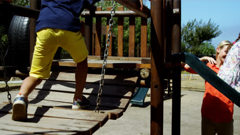 Trainer-assisting-schoolkids-while-playing-in-playground