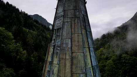 Slovenia-Small-Town-Surrounded-By-Misty-Pine-Forest-Mountains-Aerial-Drone-8