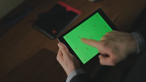 Männliche-Hand-Hält-Tablet-PC-Mit-Grünem-Bildschirm.-Nahaufnahme-Eines-Mannes,-Der-über-Den-Tablet-Bildschirm-Wischt