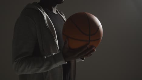 toma de estudio de cerca de un jugador de baloncesto masculino lanzando la pelota de mano en mano 1