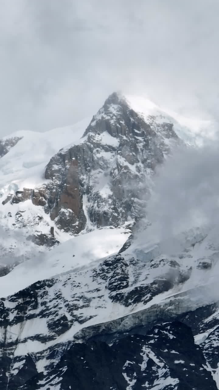 Vertical drone shot in front of the snow covered Mount Blanc peak, in France