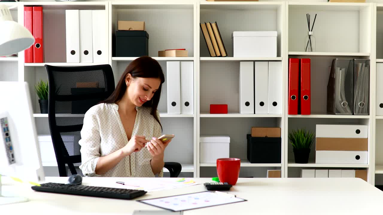 mujer de negocios en blusa blanca sonriendo y usando un teléfono inteligente