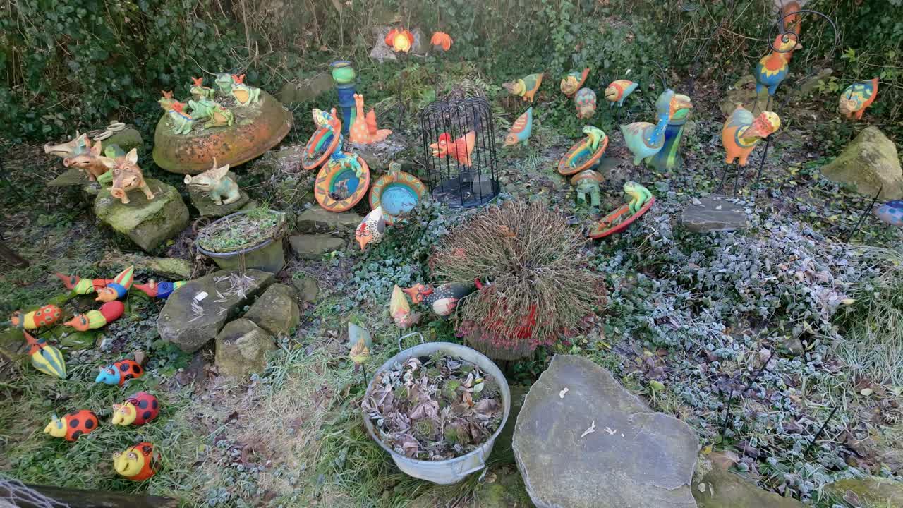 Medium shot of colorful and funny animal shaped garden sculptures during the day in the old town of Holloko, Hungary.