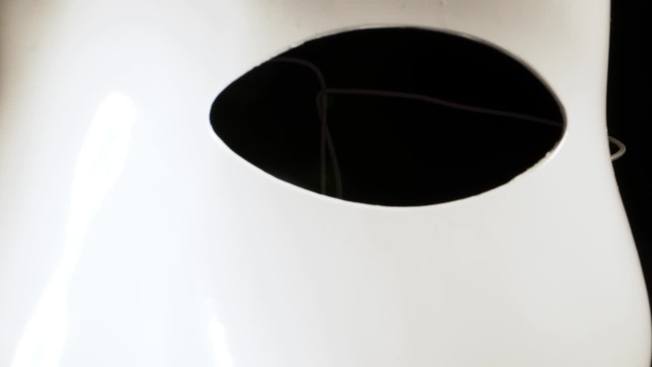 White face mask on dark background.