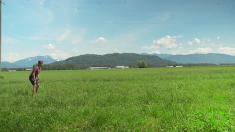 Mann,-Der-Mit-Einem-Golden-Retriever-Auf-Einem-Feld-Apportieren-Spielt