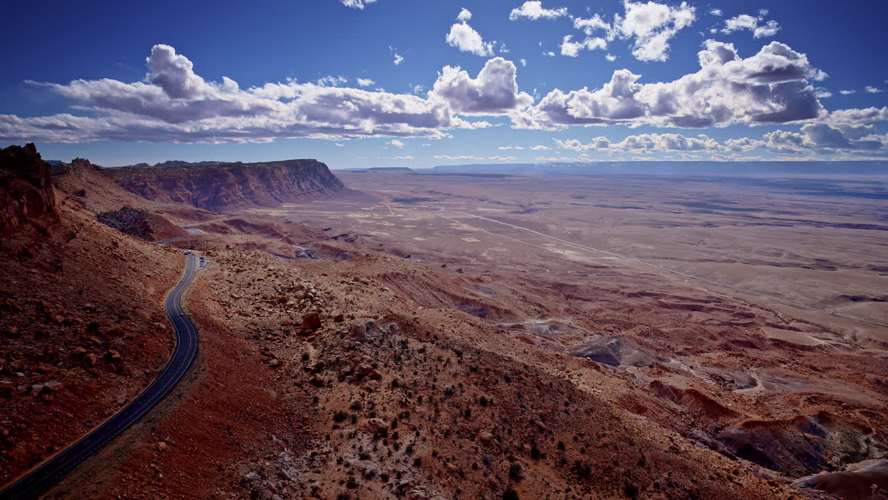 The drone hovers over a wild, winding pass chiseled through red desert stone near Page.