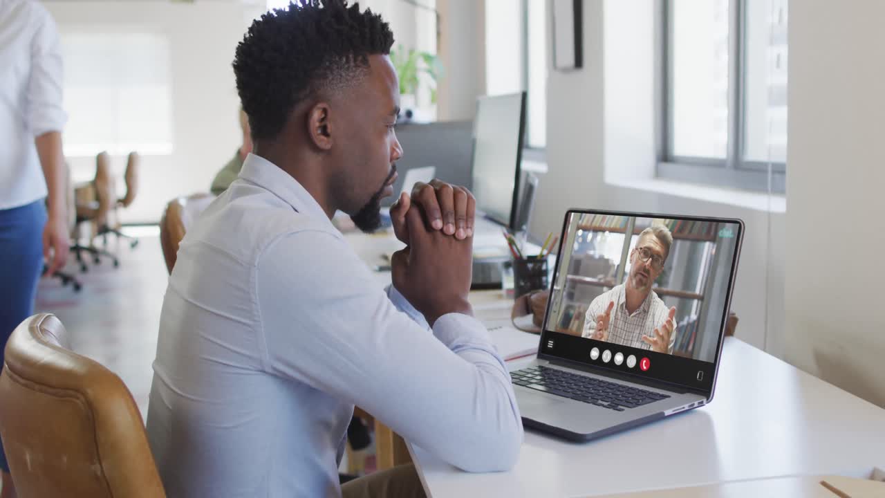 African american man using laptop for video call, with business colleague on screen