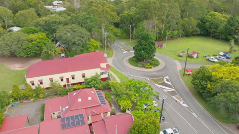 Ciclista-De-Carretera-De-Sobrevuelo-De-Drones-Montando-Bicicleta-Por-Una-Calle-Suburbana-En-Un-Pequeño-Pueblo-Rural-En-Australia,-Cámara-Lenta-De-4k