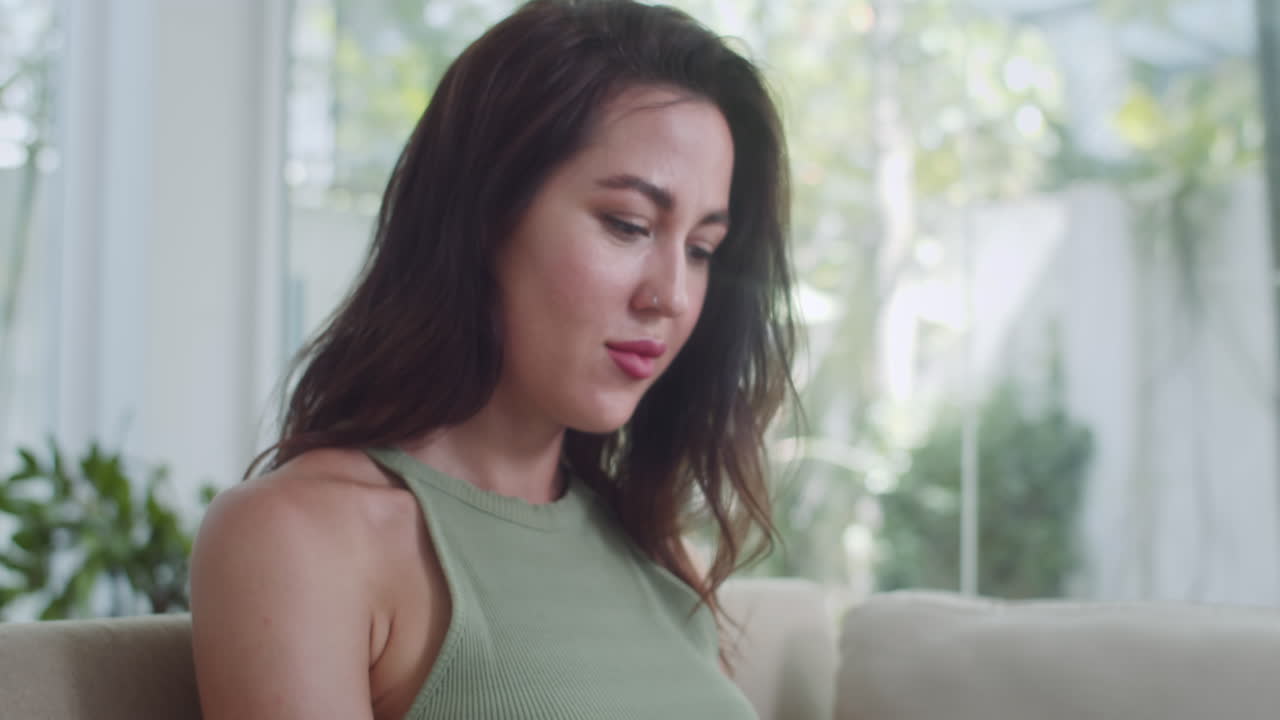 Woman Working on Laptop Sitting on Sofa
