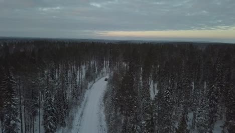 Cars-driving-through-a-snow-covered-landscape-near-Kuusamo,-Finland