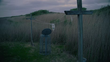 cinematic ominous abandoned washing line and bin in stormy conditions