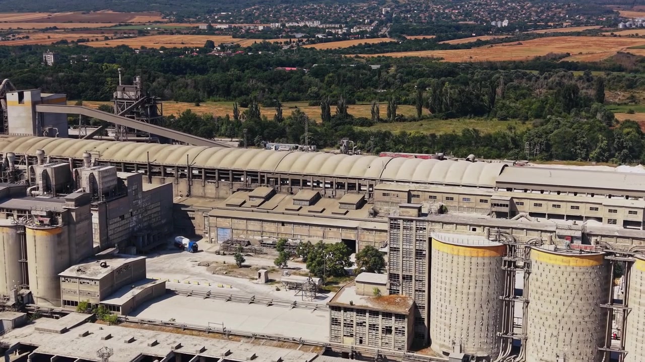Large industrial facility with silos near a train track