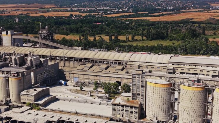 Large industrial facility with silos near a train track