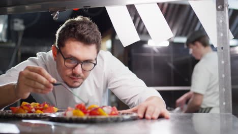 chef using tweezers for serving salad