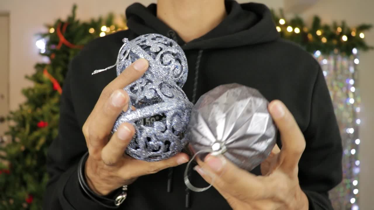 축제 로 장식 된 방 에서 은빛 으로 반이는 크리스마스 공 을 보여 주는 것