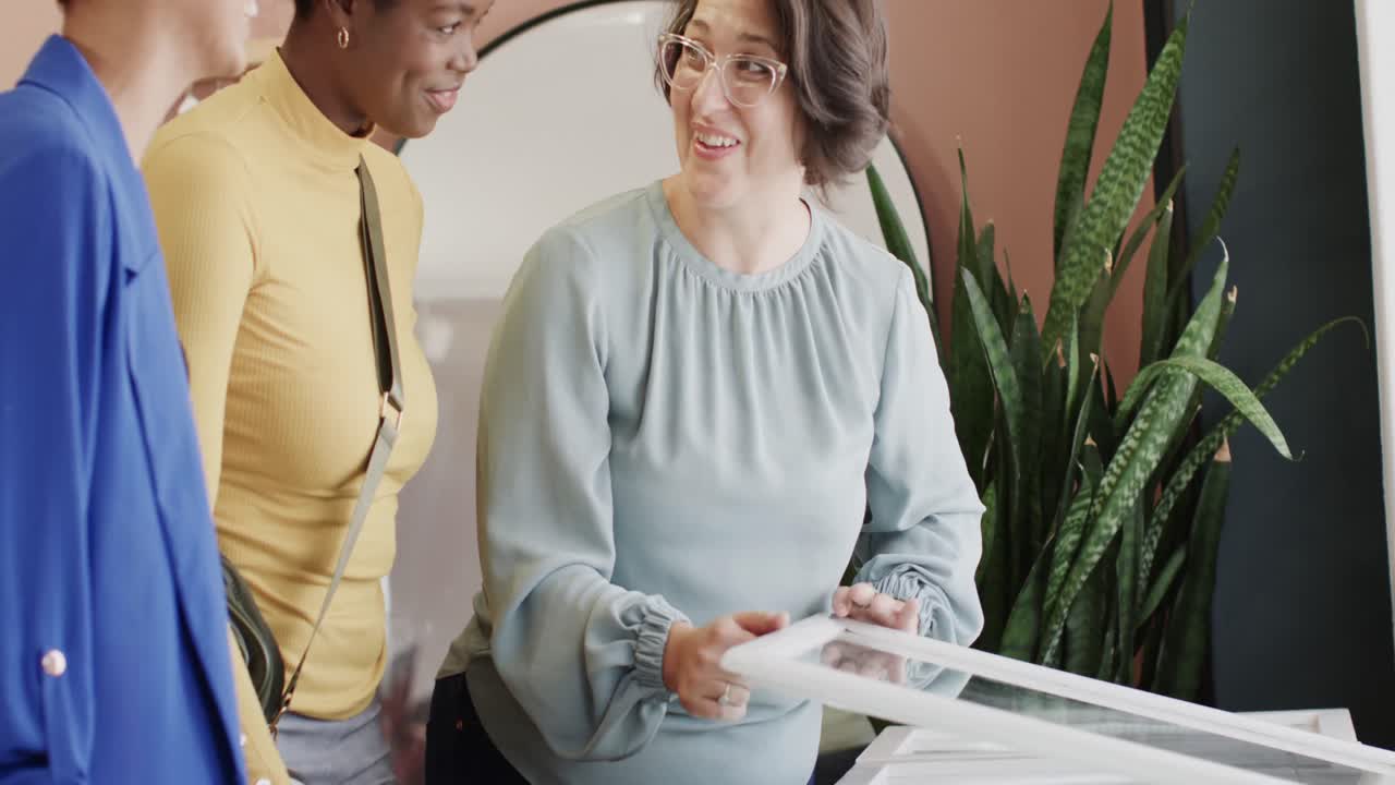mujeres felices y diversas eligiendo joyas en una joyería en cámara lenta