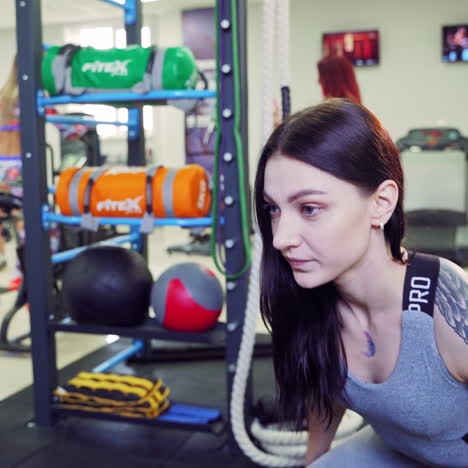 athletic woman does jumps on a big box on the background of the modern fitness gym. intense exercise jumping of a young female as her daily cross fitness training program.