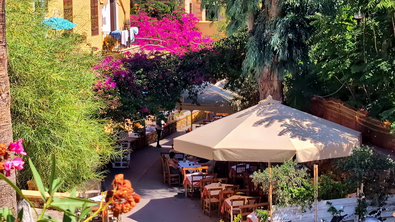 Charming outdoor cafe surrounded by lush greenery and vibrant flowers in Chania, Greece