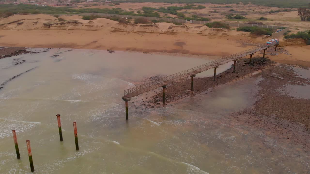 Allana Gadoor Village Beach pier extends over the sandy coastline and ocean in Sindh, Pakistan