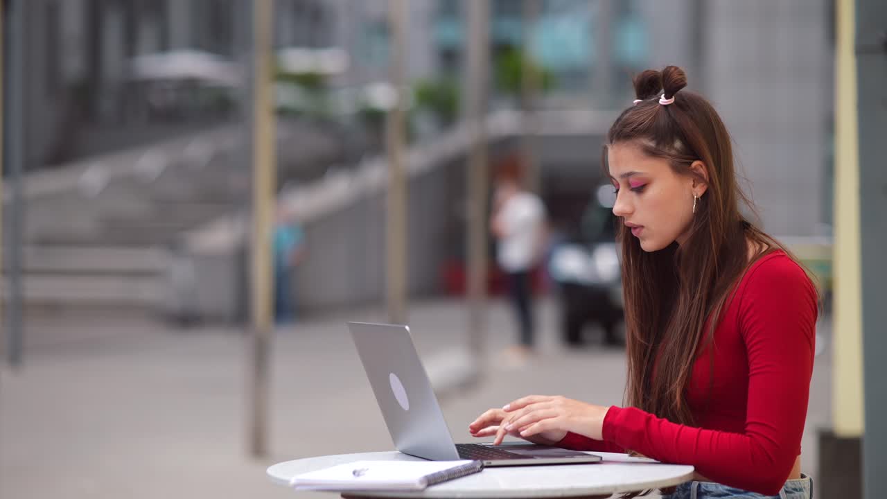 mujer joven trabajando en una computadora portátil al aire libre