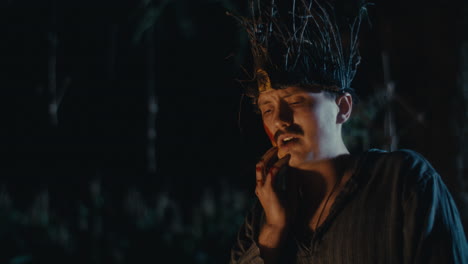 distressed man in branch crown with blood in dark forest