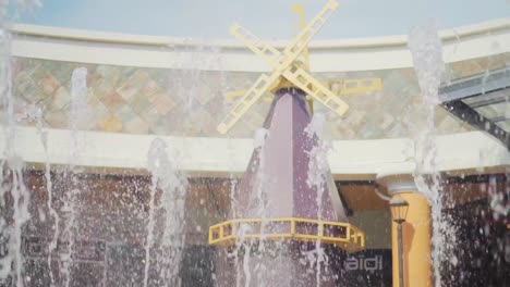 slow motion of fountains with windmill on background