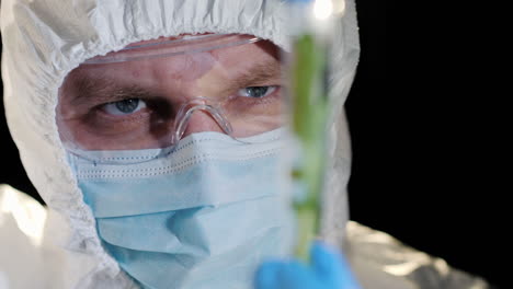 a researcher looking closely at a test tube with a green plant 1