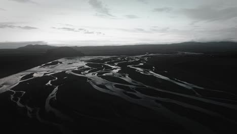 aerial thor valley, glacial river flowing through black volcanic floodplain, thorsmörk landscape national park iceland