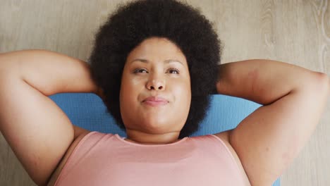 video de una mujer afroamericana de talla grande haciendo ejercicio en casa