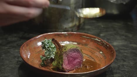 chef preparando un plato con una rodaja de costilla de carne de venado