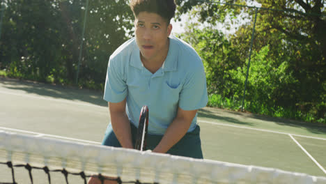 video of happy biracial man playing tennis on the court