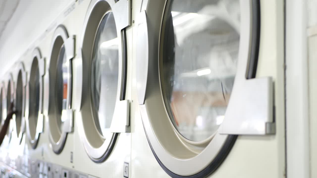 Washing machines, public coin laundry, USA. Self-service laundromat, laundrette.
