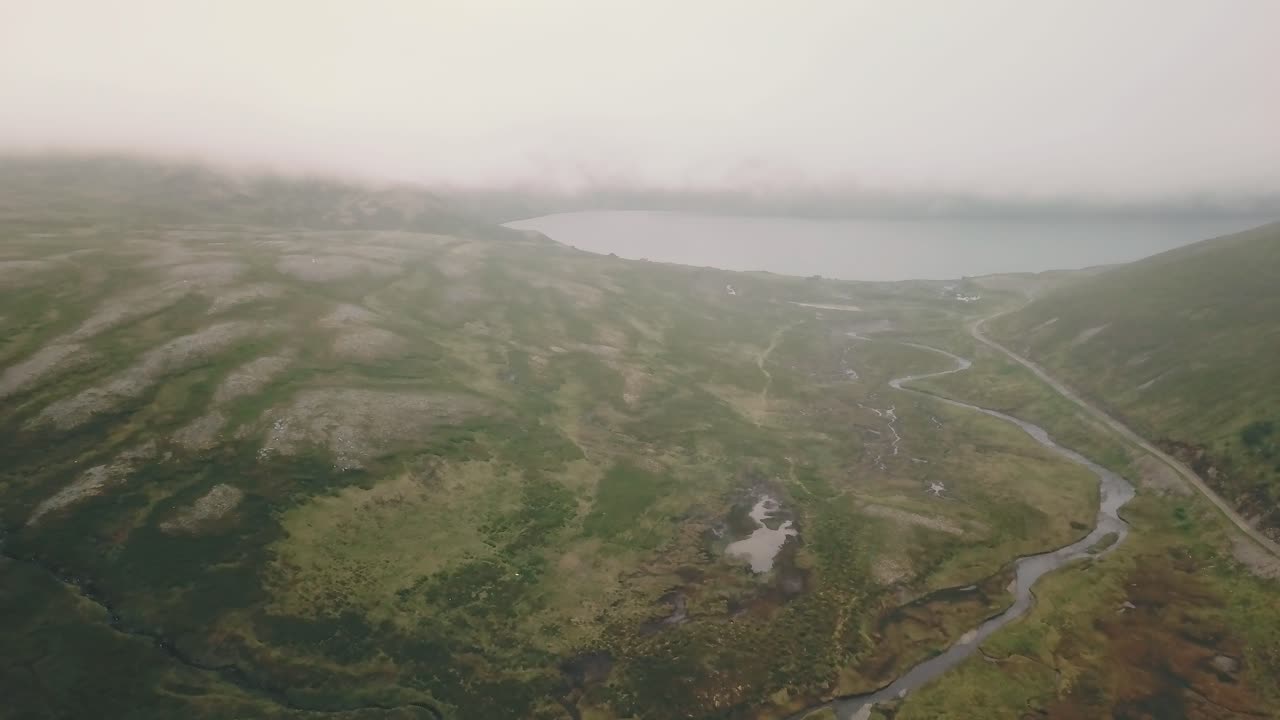 adelante, la grúa ahoga un dron disparado sobre un río en nordkapp con niebla