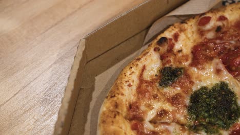 close up shot of delicious italian pizzas delivered in boxes on the wooden table at home, sliding